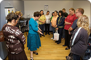 tour participants listening to 
health professional speak about assistive technology in the kitchen