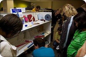 tour participants looking at a shelf of 
assistive technology