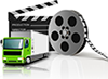 small green truck sitting in 
front of giant movie reel